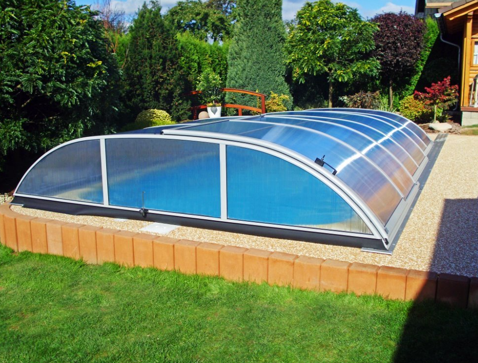 piscina su terreno in pendenza con pavimentazione a livello